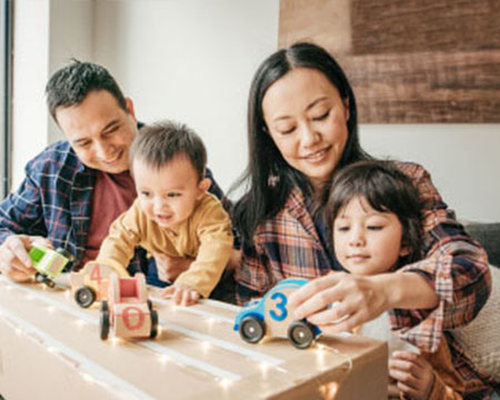 familia joven de cuatro integrantes jugando con juguetes en casa